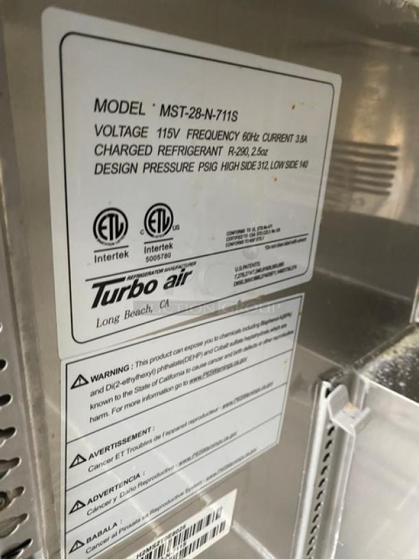 Turbo Air MST28N711S commercial salad prep table tag detailing model, voltage, refrigerant type, and warnings.