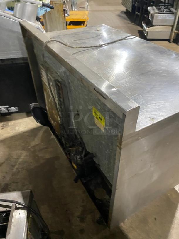 Commercial stainless steel 2-door worktop table with backsplash, poly-coated wire racks, and casters. Used condition.