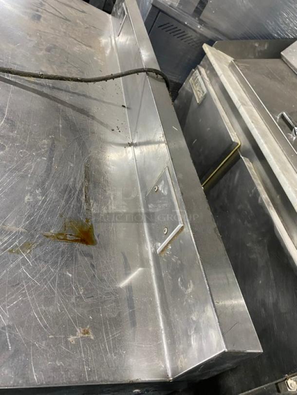 Commercial stainless steel 2-door worktop table with backsplash, poly-coated wire racks, on casters, scratched surface.