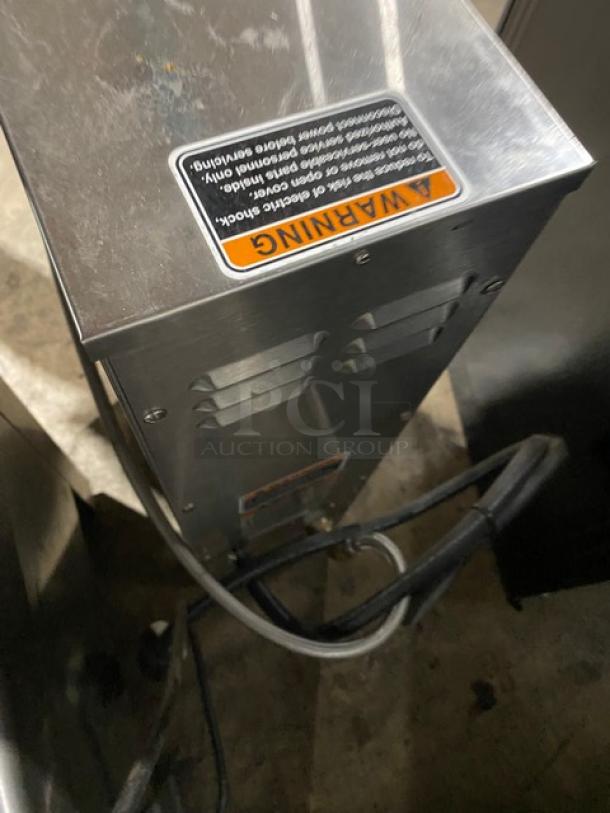 Bunn commercial stainless steel hot water dispenser with digital temperature controls, visible warning label, and power cord.