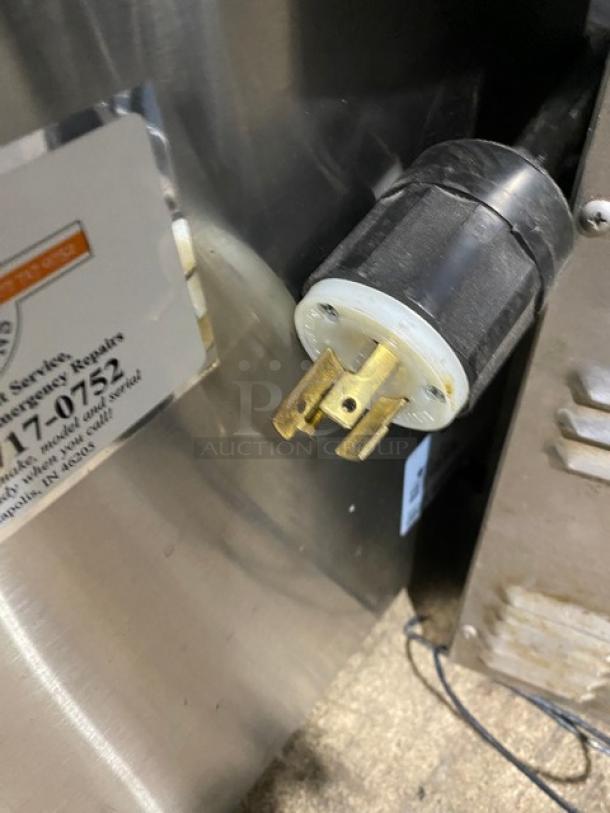 Bunn commercial stainless steel hot water dispenser with digital temperature controls, showing power plug and label.