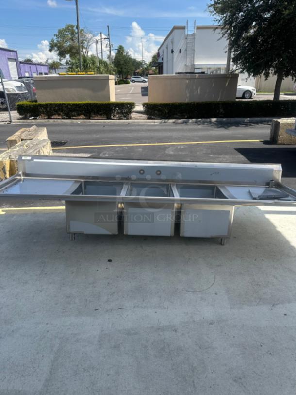 BRAND NEW Regency 104" three compartment stainless steel sink with cross bracing and two drainboards. Scratch and dent condition.