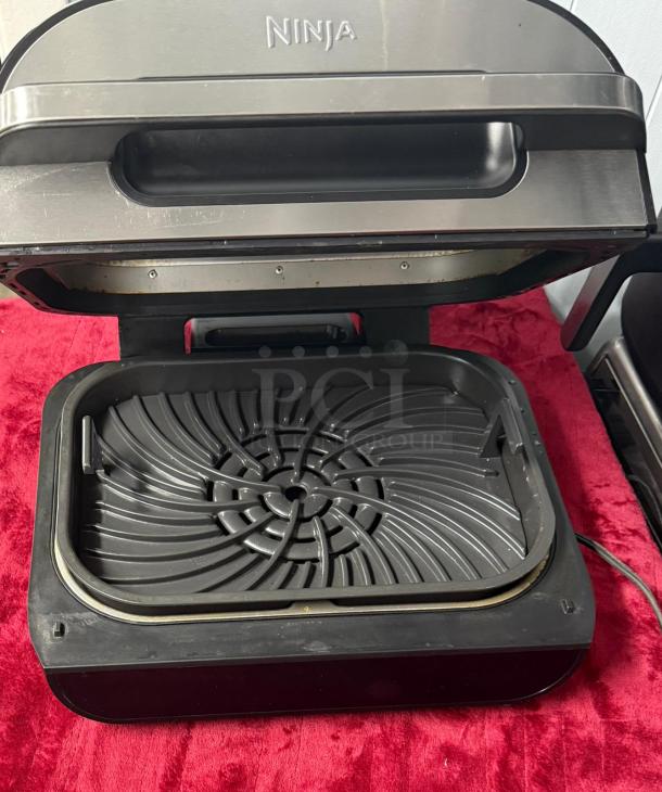 Ninja FG551 Foodi Smart XL 6-in-1 Indoor Grill, open, showcasing grill plate. Stainless steel, in good condition.