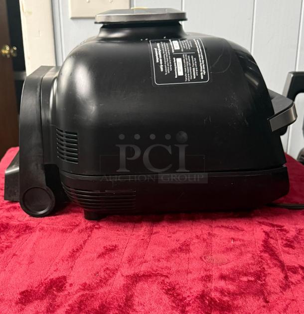 Ninja FG551 Foodi Smart XL 6-in-1 Indoor Grill, black, side view. Appears in good condition with label details visible.