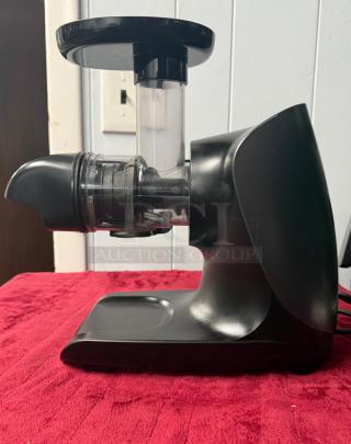 Ninja Cold Press Juicer Pro, 150W, graphite color, total pulp control, excellent condition, side view on red surface.
