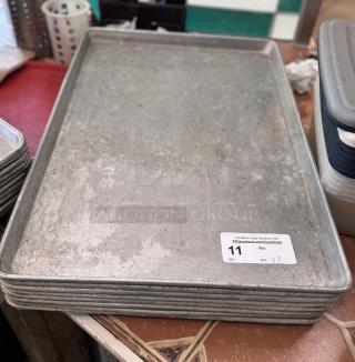 Large sheet pans, 8-count, used condition. Auction tag visible; indicates quantity and auction info.