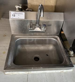 Stainless steel hand sink with two faucet handles, minor wear, auction label marked "13".