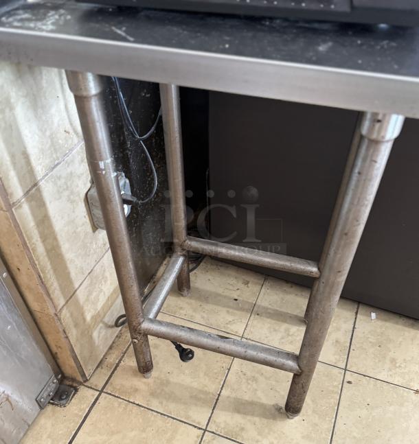 Stainless steel work table with sturdy legs. Used condition. Ideal for kitchen or industrial use.