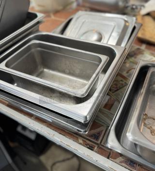 Assorted 4" steam table pans, stack of 4, stainless steel, used condition, slight wear, suitable for catering.