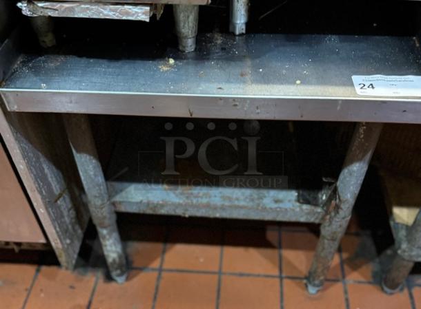 Stainless steel equipment stand, two-tier, used condition, surface marks, sturdy build, ID tag number 24 attached.