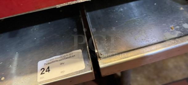 Stainless steel equipment stand with visible wear. Auction label reads "24." Durable surface, ideal for kitchen use.