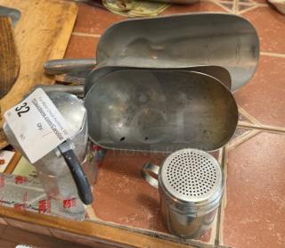 Aluminum scoops, shaker, and espresso pot set on a tile countertop. Includes item tag marked "32." Items show moderate wear.