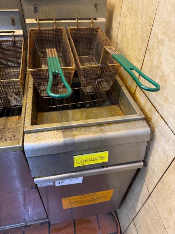 Qualite gas fryer with dual baskets, green handles, tested and working. Features yellow branding and visible wear.
