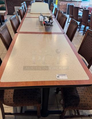 13 dining tables with beige laminate tops, brown trim. Moderate wear. Auction tag number 46 visible.