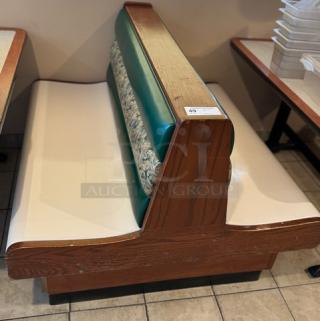 Dining room double booth with finished ends, featuring wood trim, green and patterned backrest, and cream seating. Auction tag visible.