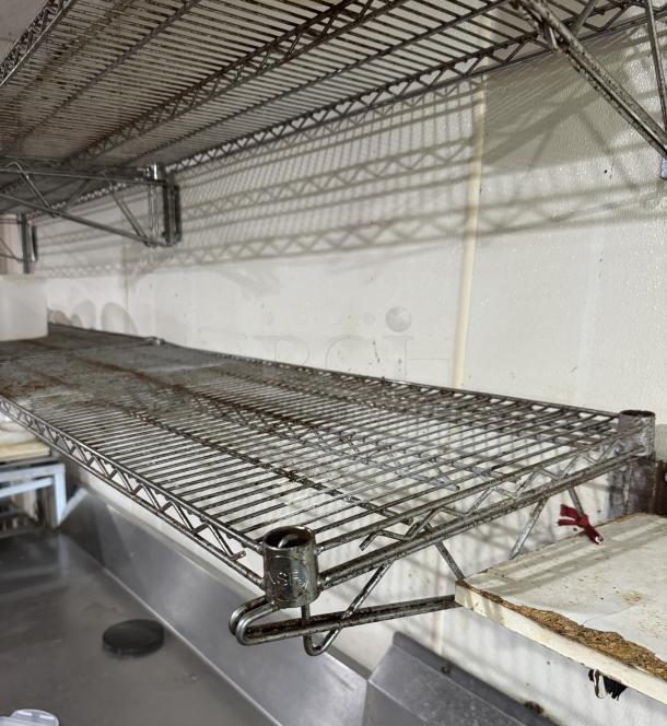 Wire wall shelving unit, four pieces, metal, used condition with noticeable rust, ideal for storage organization.