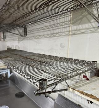 Wire wall shelving unit, four pieces, metal, used condition with noticeable rust, ideal for storage organization.