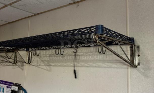Wire wall shelving unit with hooks, mounted on a wall. Appears sturdy and in good condition for organizing items.