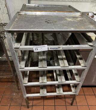 Stainless steel 303 can rack with multiple shelves. Visible wear and rust. Label indicates "Channel" brand. Auction lot tag "73".