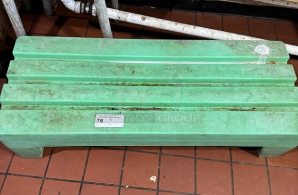 Green dunnage rack, used condition, showing label with number 76. Sturdy design for storage organization on tile floor.