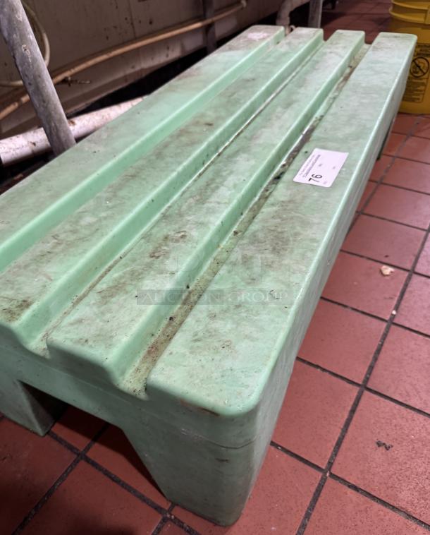 Green plastic dunnage rack with slatted top, showing moderate wear and dirt. Auction tag labeled "76" visible.