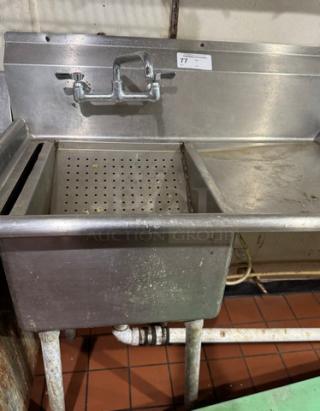 Stainless steel 1 compartment sink with drain board, built-in strainer, and faucet. Numbered tag on backsplash. Used condition.