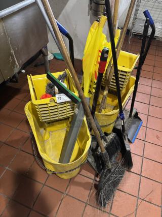 Assorted cleaning equipment includes yellow buckets, brooms, and mops in used condition; auction tag visible.