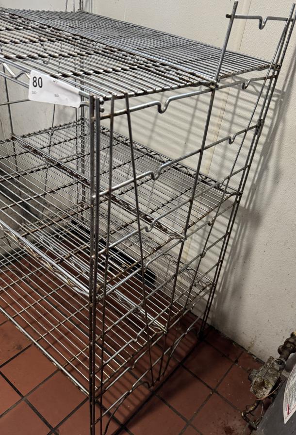 Metal floor rack with five wire shelves, lightly rusted, numbered tag 80, suitable for storage or display.