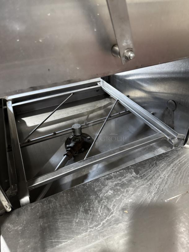 Industrial dishwasher interior, stainless steel base, with 3 Diversey detergent buckets. Clean and well-maintained condition.