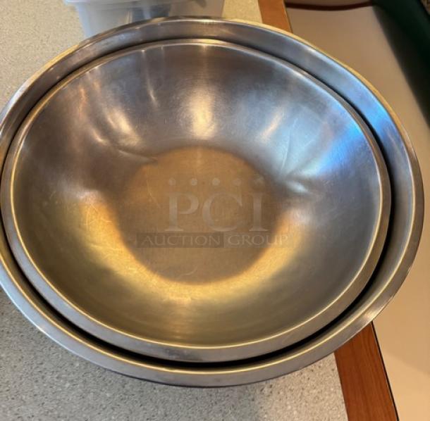 Two metal mixing bowls, sizes 16" and 18", in good condition. Ideal for culinary use. Durable stainless steel.