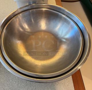 Two metal mixing bowls, sizes 16" and 18", in good condition. Ideal for culinary use. Durable stainless steel.