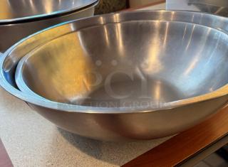 Two stainless steel mixing bowls in excellent condition, nested. Smooth finish, ideal for kitchen use. Perfect for auctions.