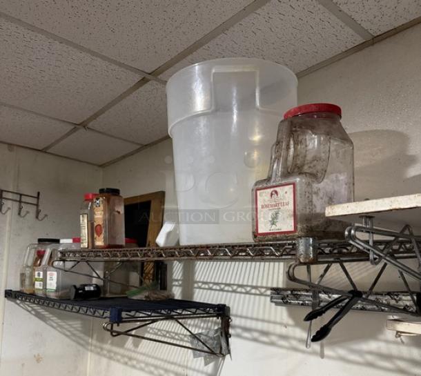 Wire wall shelving with grid design, two-tiered, used condition. Holds various containers and items, suitable for storage.