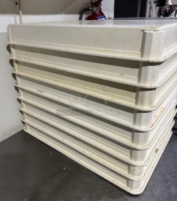 Stack of eight white dough pans, rectangular, gently used, sturdy design, suitable for commercial baking use.