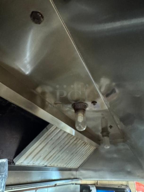 Mannbuilt stainless hood, commercial-grade, includes light fixtures and vent panel. Good condition, ideal for kitchen use.