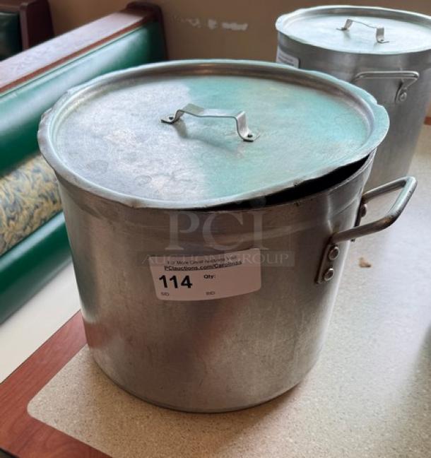 24 Qt. Chefs Stock Pot with Lid, metal finish, side handles, visible wear. Auction tag with lot number 114 attached.