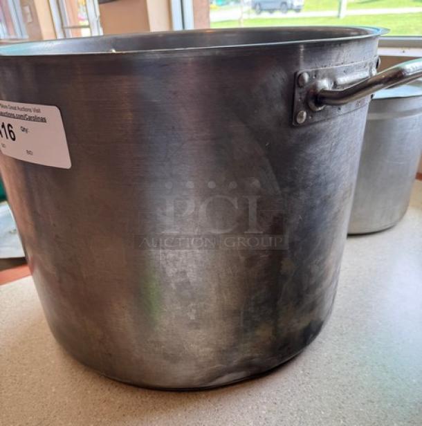 Large 60 Qt. chefs stock pot with side handles, stainless steel, used condition. Auction tag attached. Ideal for commercial cooking.