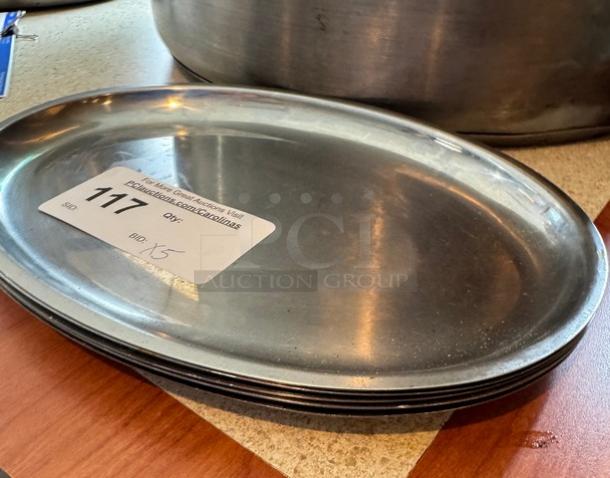Stack of five oval metal trays with auction sticker labeled "117" and bid details. Appears in good condition.