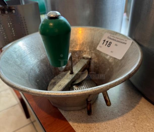 Vintage metal ricer with green handle, functional condition, auction tag marked "118".