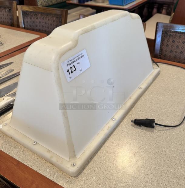 Magnetic car advertisement sign, white, rectangular with rounded edges, features plug attachment. Sale tag labeled "123."