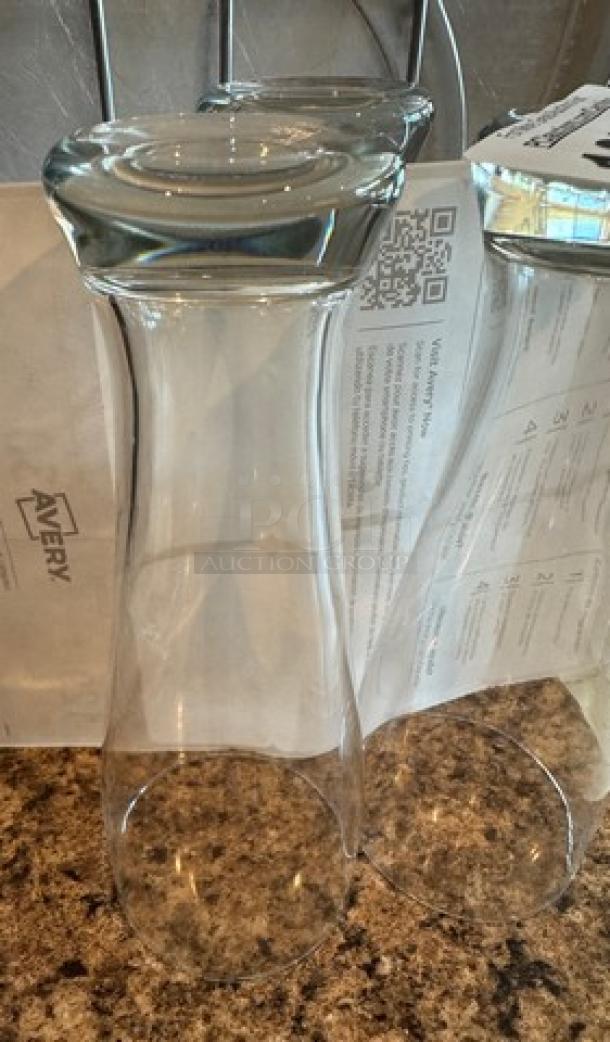 Two clear beer glasses, tall with a wide rim, in excellent condition. Set against a countertop with a QR code and text in the background.