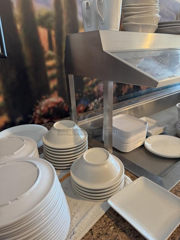 10 ft. wooden cabinet with stainless steel salad bar insert, featuring stacked white dinnerware; dinnerware not included.