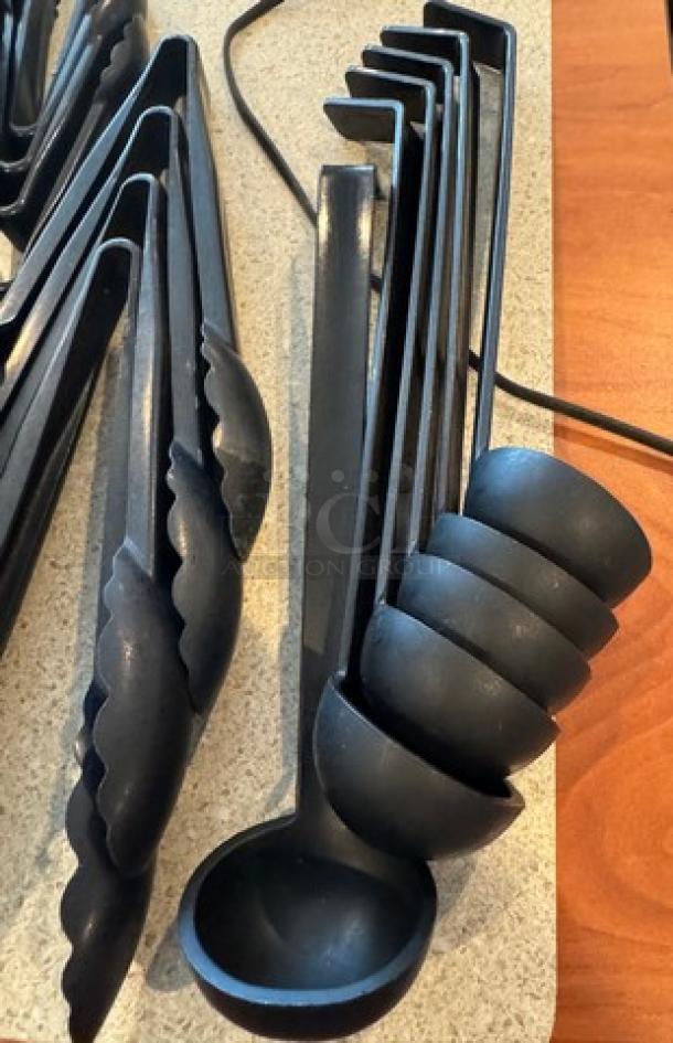Assorted black plastic tongs and ladles, 24 pieces. Durable, scalloped-edge design, ideal for kitchens or catering.