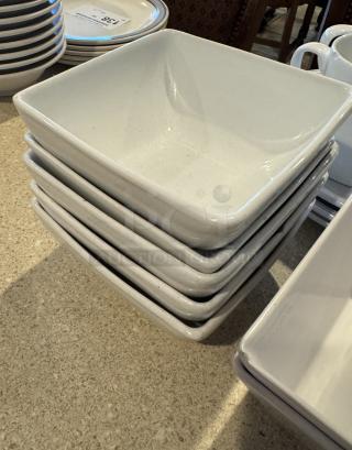 Assorted white ceramic deep bowls, plates, and cups, stacked neatly. Minimalist design, good condition, set of 14.