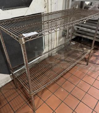 Two-tier metal shelving unit with wire grid design and visible wear. Auction tag indicates item number 99.