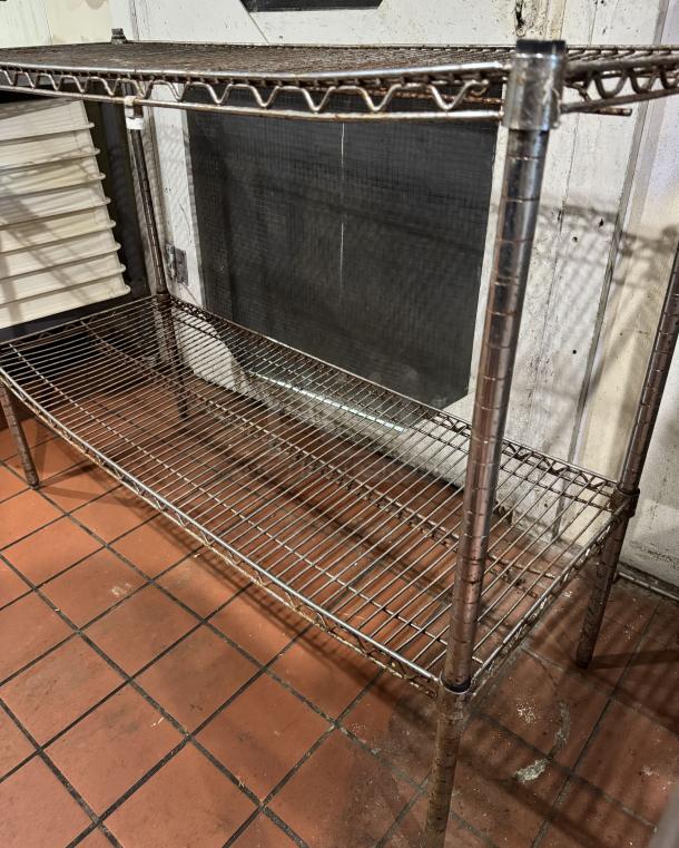 2-tier metal shelving unit with wire shelves, industrial style, shows signs of wear, sturdy construction, rust visible.