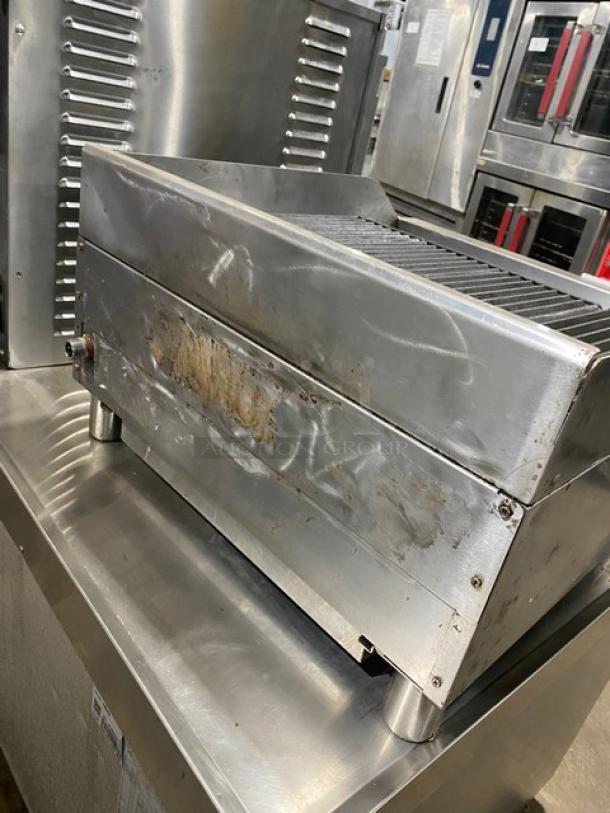 Globe stainless steel countertop char broiler on legs, natural gas powered, SN: 1715042736, visible wear, commercial use.