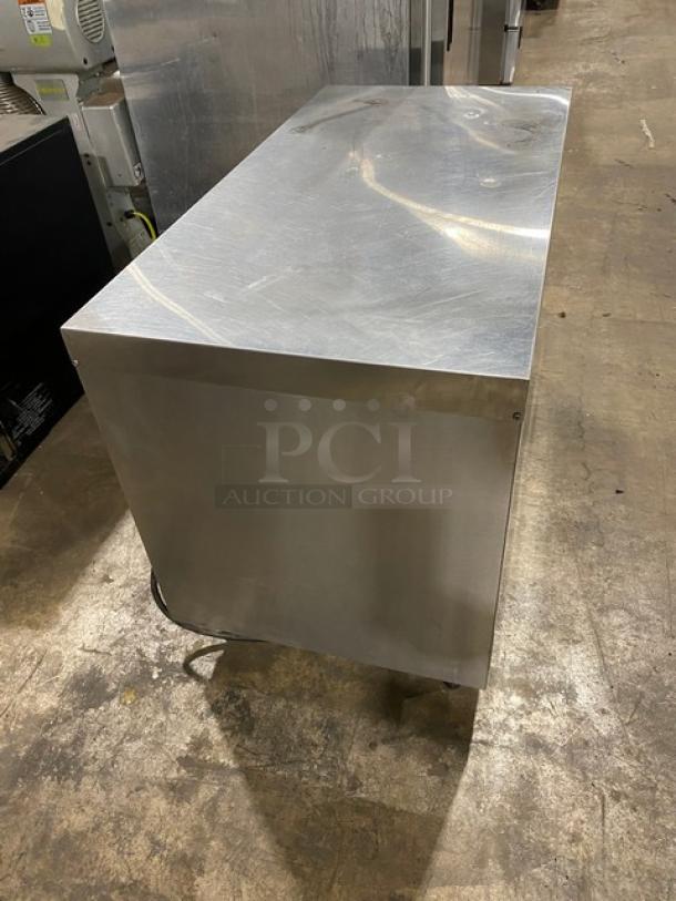 Commercial stainless steel countertop heated merchandiser display case with wired racks on legs. 