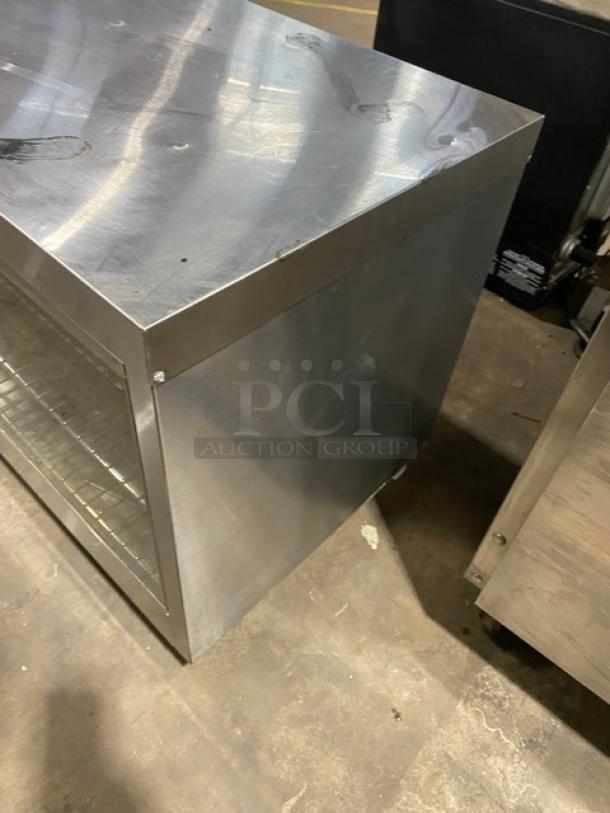 Commercial stainless steel countertop heated display case, electric powered, with wired racks, on legs, good condition.