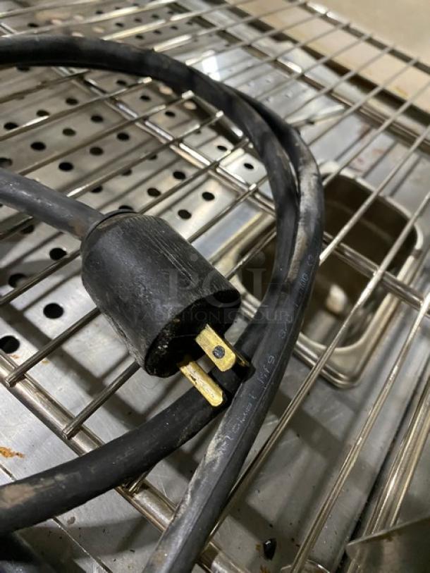 Commercial stainless steel electric countertop heated merchandiser with wired racks and a power cord.